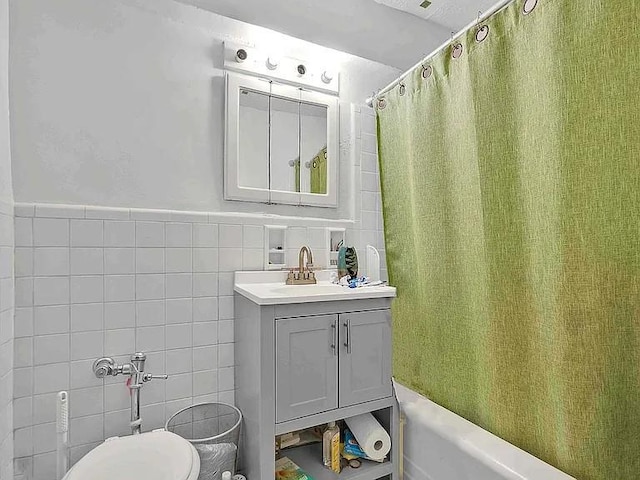 full bathroom with vanity, shower / bathtub combination with curtain, tile walls, and toilet