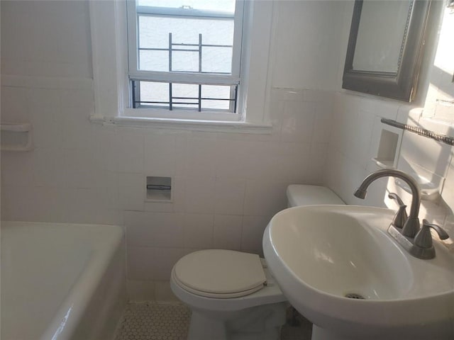 bathroom with sink, a bath, tile walls, and tile patterned flooring