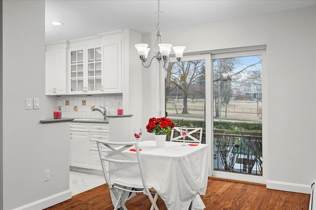 dining room with sink, hardwood / wood-style floors, and a notable chandelier