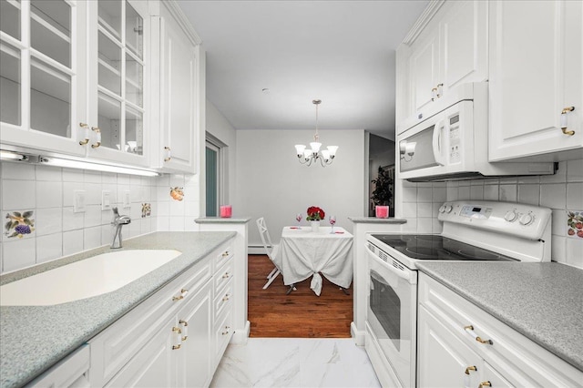 kitchen with white cabinetry, sink, white appliances, and hanging light fixtures