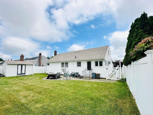 back of house featuring a lawn, a patio area, and a storage shed