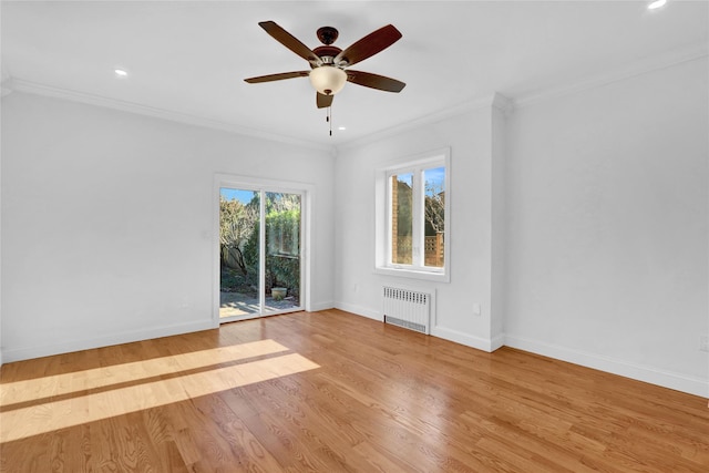 spare room featuring crown molding, radiator heating unit, and light wood-type flooring