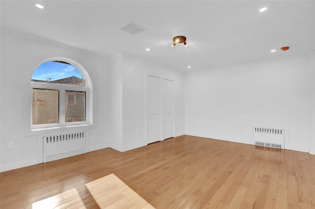 spare room featuring light hardwood / wood-style floors and radiator