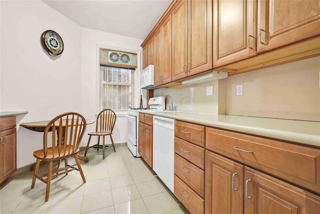 kitchen with sink, light tile patterned floors, and white appliances