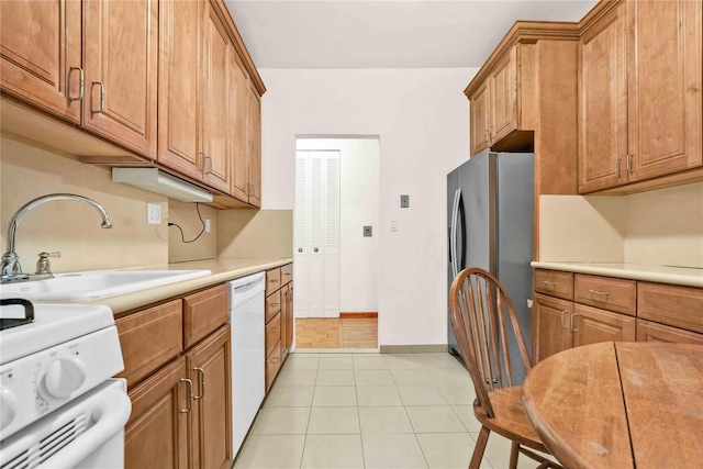 kitchen featuring white appliances, sink, and light tile patterned floors