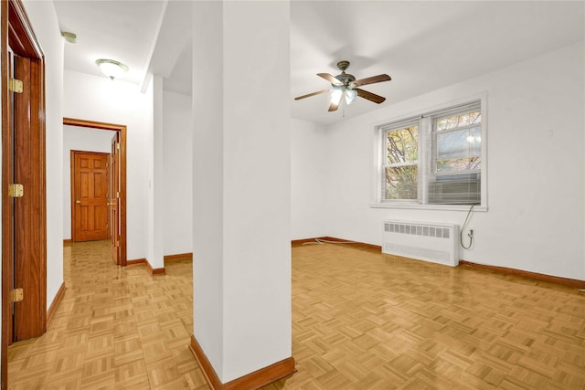 unfurnished room featuring light parquet floors, radiator, and ceiling fan