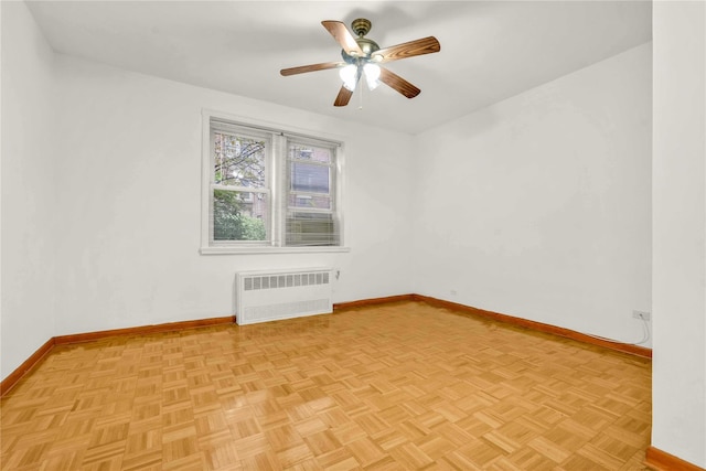 spare room with ceiling fan, radiator heating unit, and light parquet floors