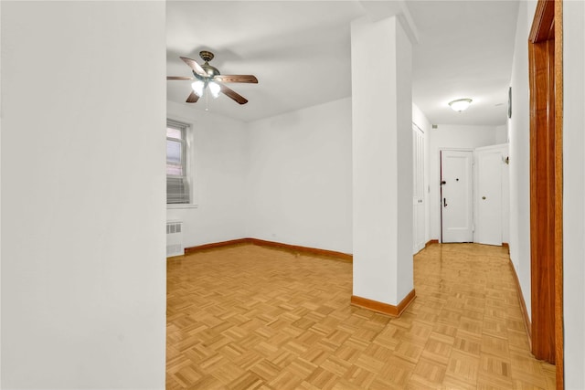 spare room featuring radiator heating unit, light parquet flooring, and ceiling fan