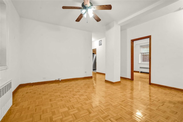 empty room with ceiling fan, radiator heating unit, and light parquet flooring