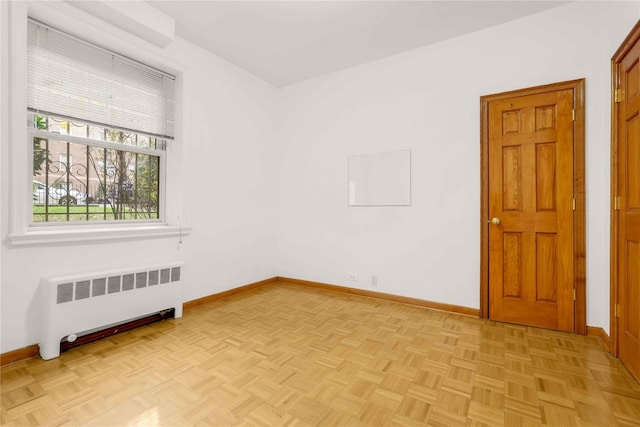 empty room featuring radiator and light parquet floors