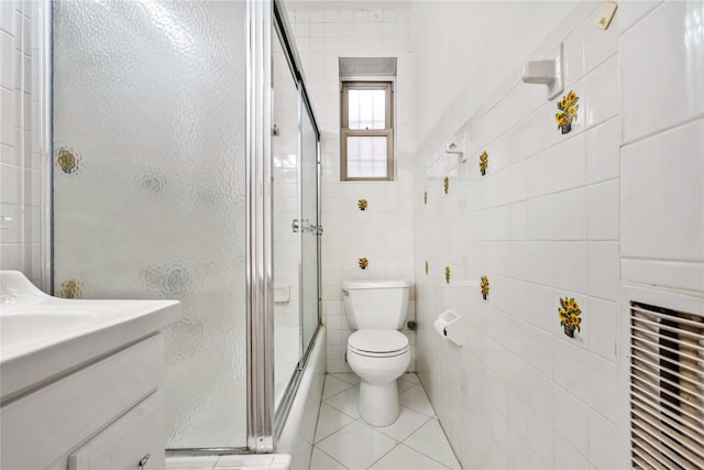 bathroom with tile patterned floors, vanity, tile walls, and toilet