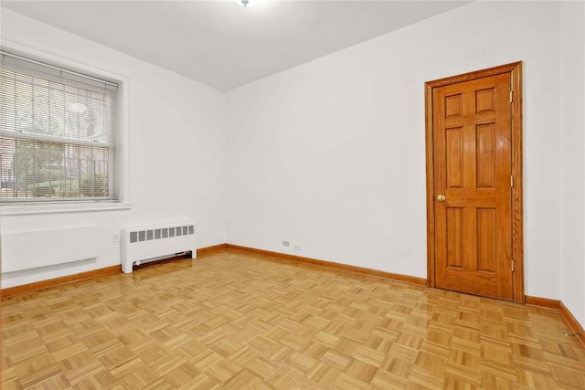 unfurnished room with radiator and light parquet floors