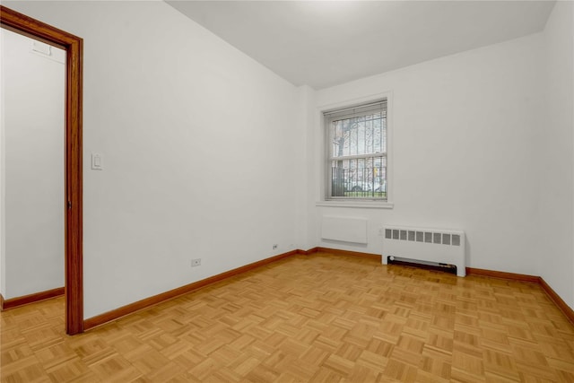 empty room with radiator, light parquet flooring, and lofted ceiling