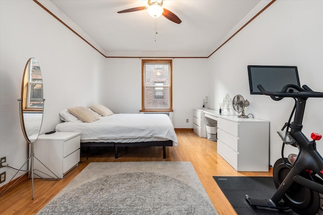 bedroom with ceiling fan, ornamental molding, and light wood-type flooring