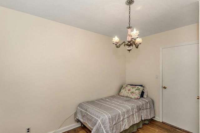 bedroom with wood-type flooring and a notable chandelier