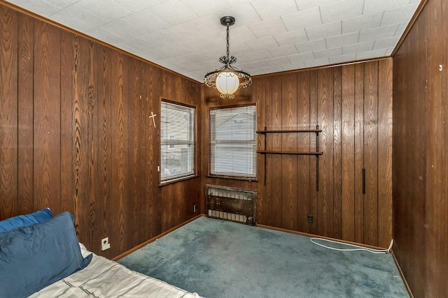 spare room with carpet, radiator heating unit, and wooden walls