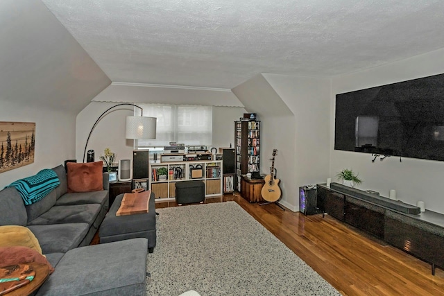 living room with hardwood / wood-style floors, a textured ceiling, and vaulted ceiling