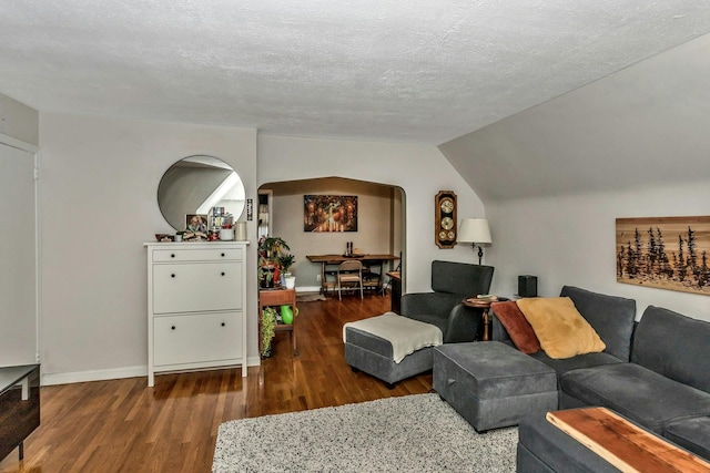 living room featuring a textured ceiling, dark hardwood / wood-style flooring, and vaulted ceiling