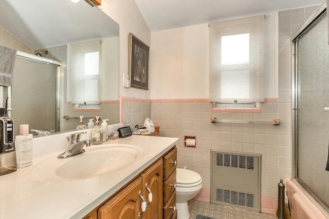 full bathroom with radiator heating unit, tile walls, and vaulted ceiling