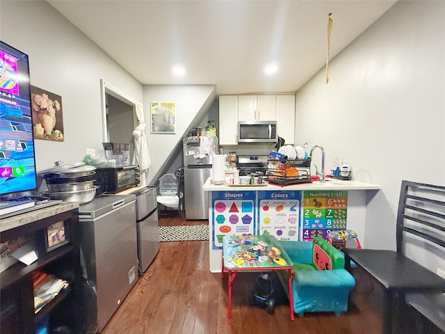 kitchen featuring sink, dark hardwood / wood-style flooring, white cabinetry, and stainless steel appliances