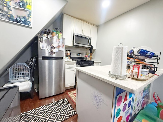 kitchen with dark hardwood / wood-style floors, white cabinetry, and stainless steel appliances