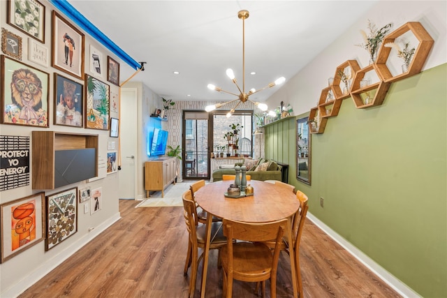 dining room with light hardwood / wood-style flooring and an inviting chandelier