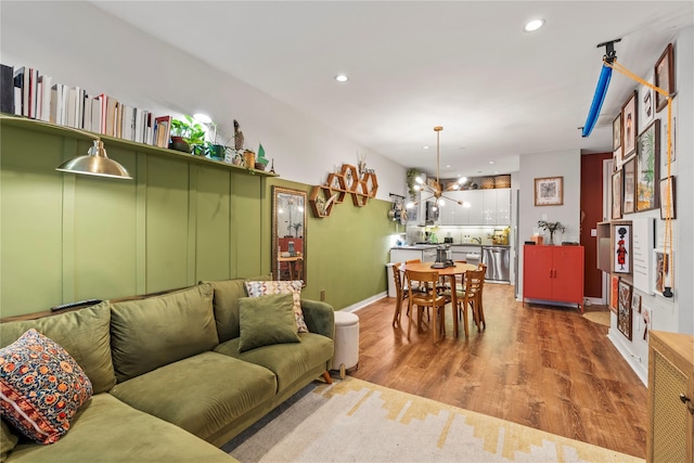 living room featuring a notable chandelier and light wood-type flooring