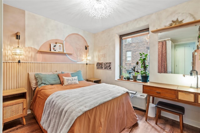 bedroom with hardwood / wood-style flooring and an inviting chandelier