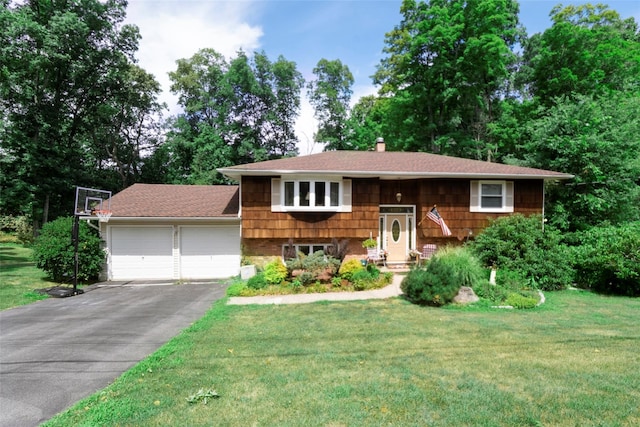 raised ranch featuring a garage and a front lawn