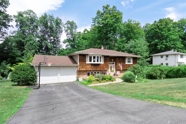 bi-level home featuring a garage and a front lawn