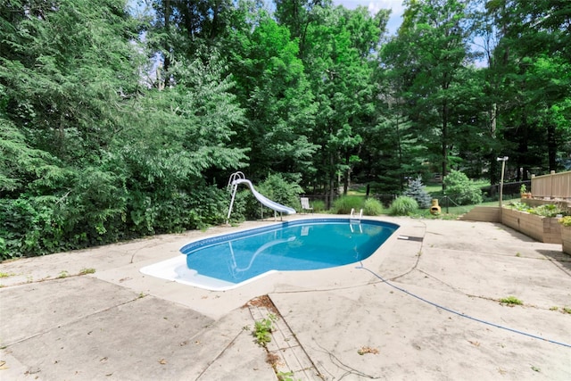 view of swimming pool with a patio and a water slide