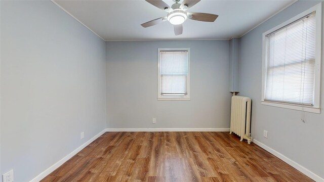 unfurnished room featuring crown molding, radiator heating unit, and light hardwood / wood-style flooring