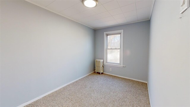 unfurnished room with radiator heating unit and light colored carpet