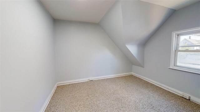 bonus room with lofted ceiling and carpet floors