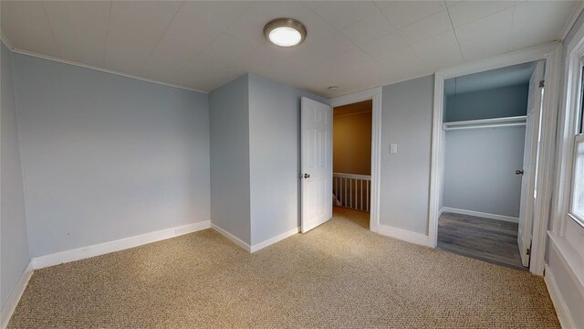 unfurnished bedroom featuring light carpet and a closet