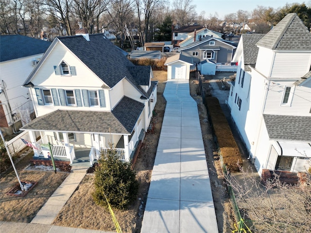 view of front of property with a porch, a garage, a residential view, and roof with shingles