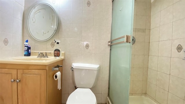 bathroom with tile walls, vanity, an enclosed shower, and toilet