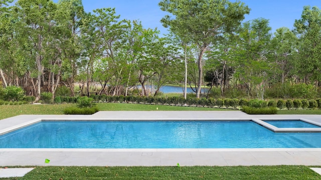 view of pool with an in ground hot tub, a water view, and a lawn