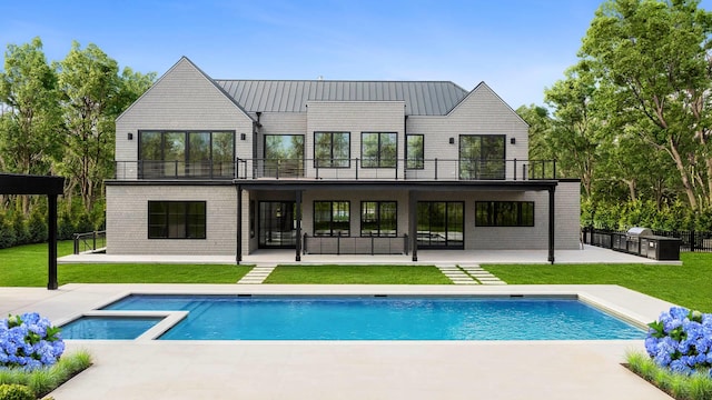 rear view of property with a balcony, a patio area, and a lawn