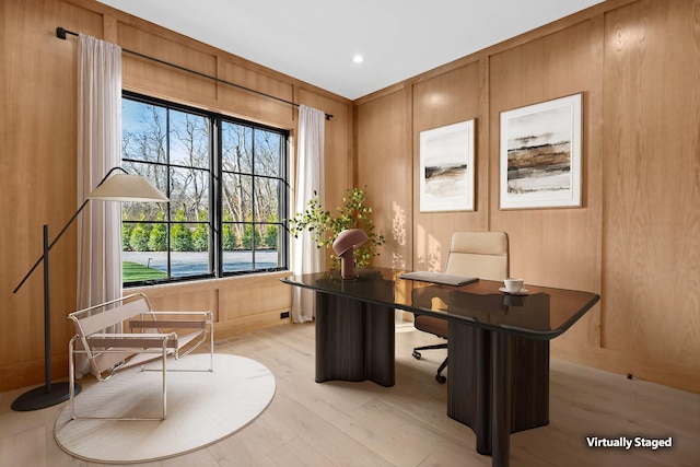 home office featuring wooden walls and light hardwood / wood-style floors