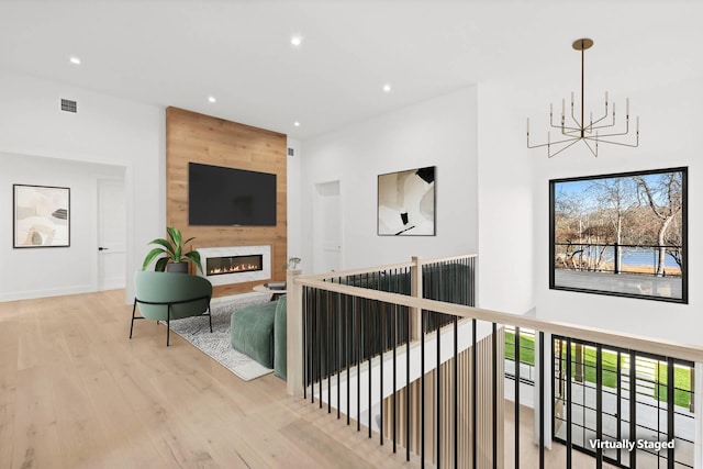 hall featuring an inviting chandelier and light hardwood / wood-style floors