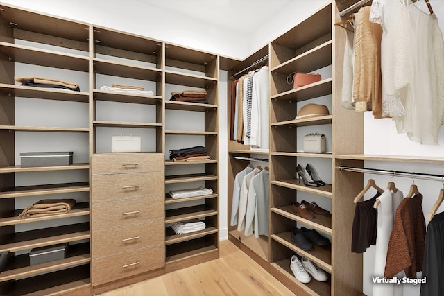 walk in closet with light hardwood / wood-style floors