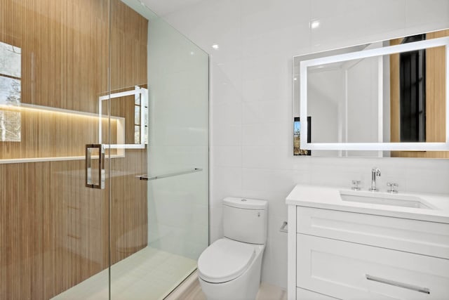 bathroom with vanity, tile walls, an enclosed shower, and toilet