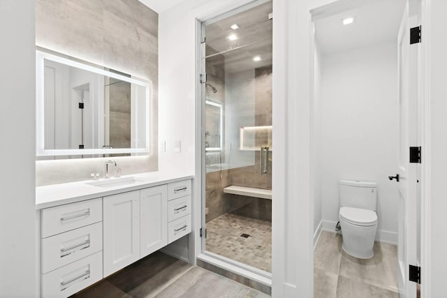 bathroom featuring vanity, an enclosed shower, and toilet