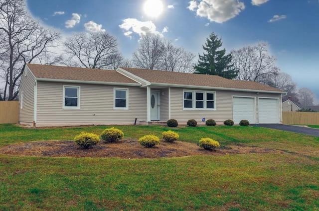 ranch-style home featuring a garage and a front lawn