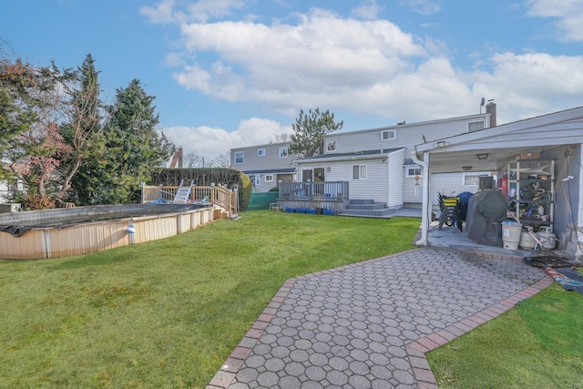 view of yard featuring a patio and a pool side deck