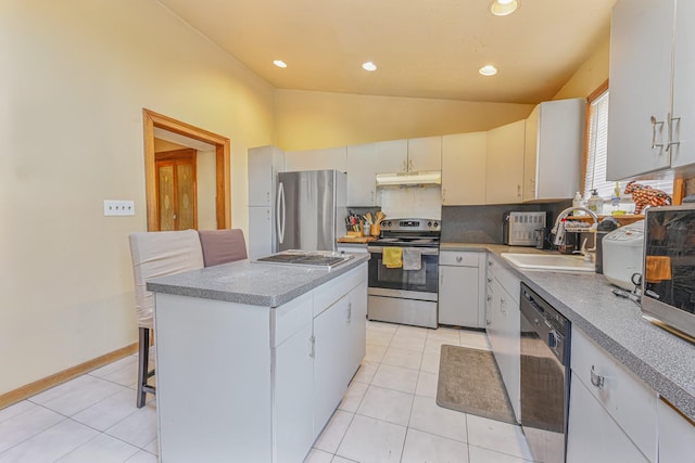 kitchen with stainless steel appliances, sink, white cabinetry, a kitchen island, and lofted ceiling