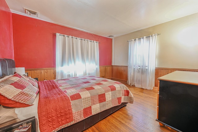 bedroom featuring wood-type flooring and wooden walls