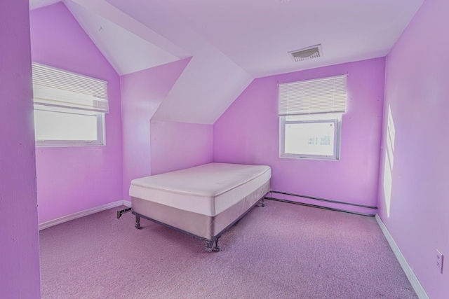 bedroom with light colored carpet, lofted ceiling, and a baseboard heating unit