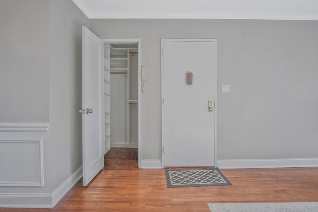 foyer entrance featuring crown molding and light wood-type flooring